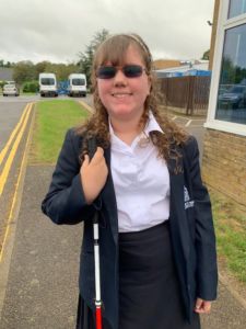 Emma in her school uniform with her cane